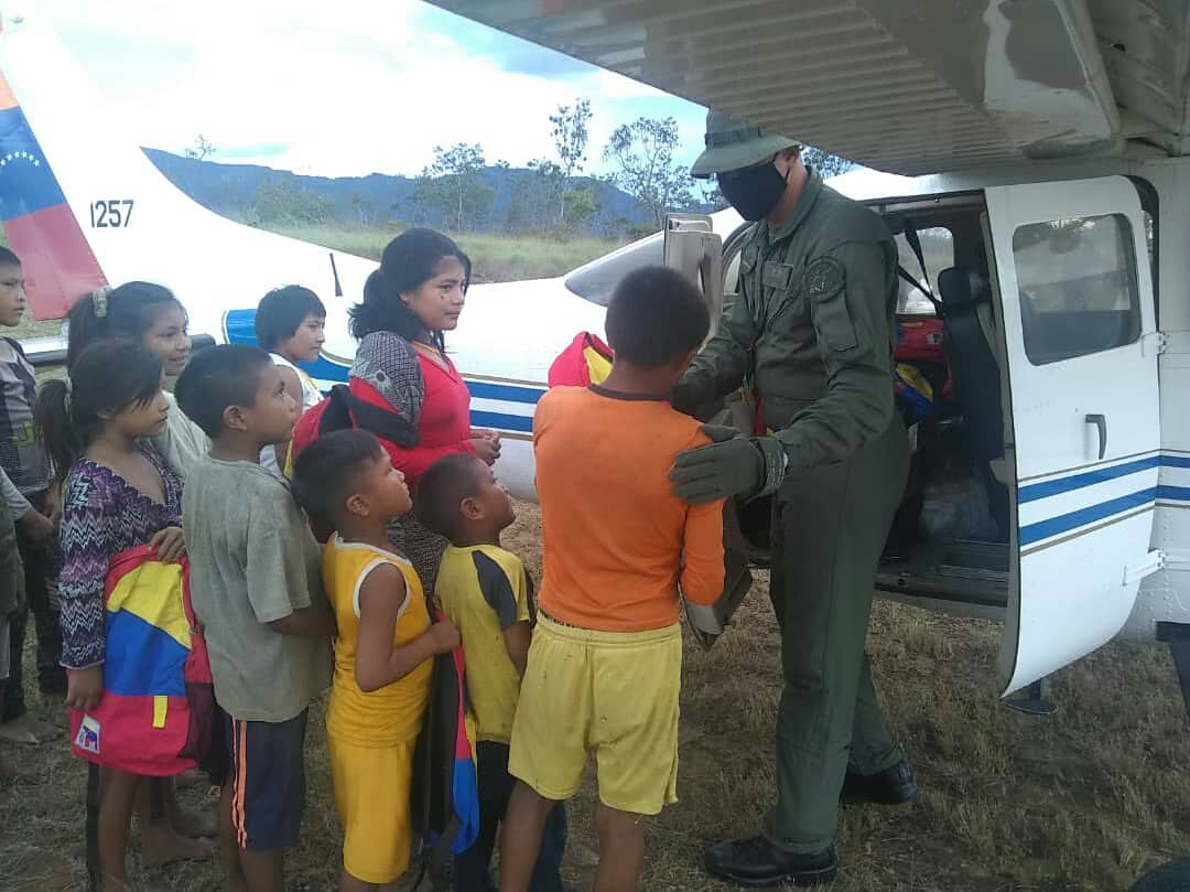 Piloto del AMB-1257 entregando material de educacin a miembros de la comunidad Yanomami (Foto: Aviacin Militar Bolivariana)
